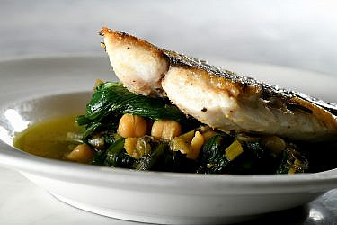תבשיל עלים ירוקים עם חומוס ודג צלוי של שף עינב אזגורי. צילום: רן בירן